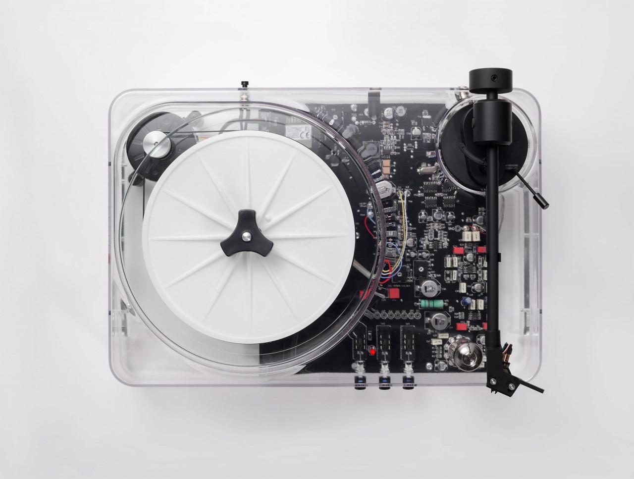 A transparent turntable by Gearbox, its circuitry and mechanics fully visible beneath the platter.
