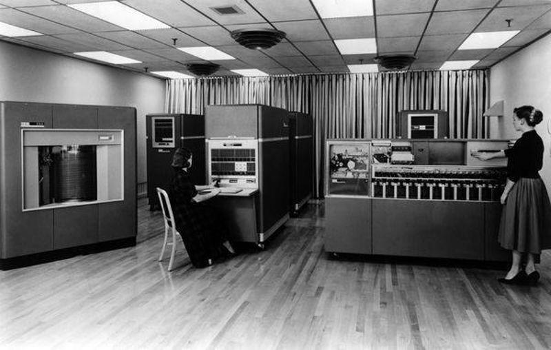 Two operators at an IBM 650 magnetic drum data-processing machine in a mid-century office.